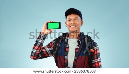 Hiking, green screen and man with a smartphone, portrait and backpack on a blue studio background. Person, hiker and model with mockup space, digital app and cellphone with tracking markers or travel