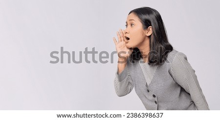 Beautiful young Asian woman in casual clothes holding a hand near mouth, telling a secret, whispering gossip isolated on white background. People lifestyle emotion concept Royalty-Free Stock Photo #2386398637
