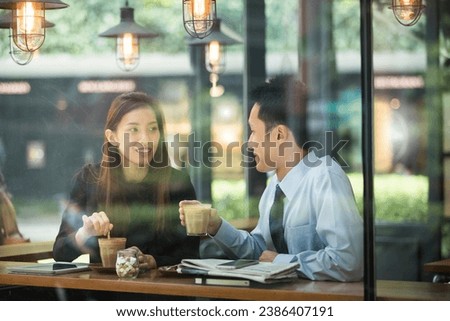 Asian business man and woman meeting in a coffee shop. Royalty-Free Stock Photo #2386407191