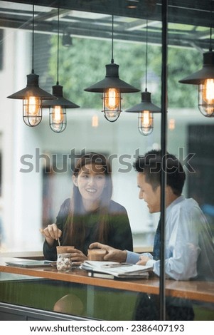 Asian business man and woman meeting in a coffee shop. Royalty-Free Stock Photo #2386407193