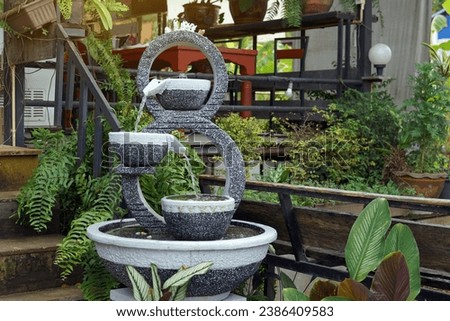 A set of overflowing water in the shape of a number 8, made from fresh stucco with a stone pattern, used to decorate a garden in a natural style to make it beautiful according to Feng Shui principles. Royalty-Free Stock Photo #2386409583