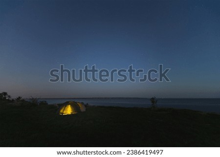 Wild camping with a tent at night in summer. Starry sky, Paldiski cliff. . High quality photo