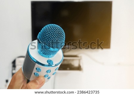 Man's hand holding a microphone to sing