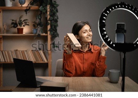 Vlogger making an unboxing video for her tech channel, opening a delivery box with new parcel. Copy space