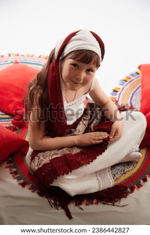 Portrait of Little girl in a stylized Tatar national costume on a white background in the studio. Photo shoot of funny young teenager who is not professional model