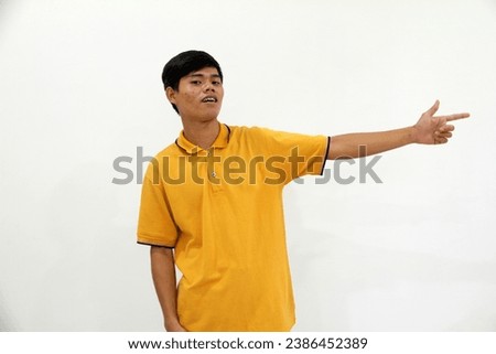 Adult Asian man showing excited expression while pointing to the left side
