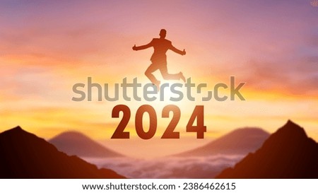 Silhouette of a person leaping from 2023 to 2024 on the top of the mountain background. Happy New Year and Christmas day concept. Royalty-Free Stock Photo #2386462615