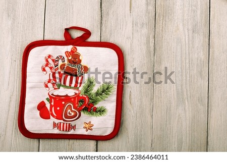 New Year's gloves. A grab for hot dishes.wooden background. free space for text.New Year's concept.Santa Claus clothes.