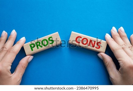 Pros vs Cons symbol. Concept word Pros vs Cons on wooden blocks. Businessman hand. Beautiful blue background. Business and Pros vs Cons concept. Copy space