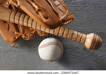Baseball glove, bat and ball on grey wooden table, closeup