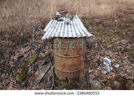 An old drum with a zinc plate on top to use rainwater for later irrigation