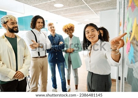 Chinese woman using post-its to explain ideas in a coworking Royalty-Free Stock Photo #2386481145