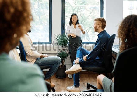 Chinese woman talking during a relaxed meeting on a coworking Royalty-Free Stock Photo #2386481147