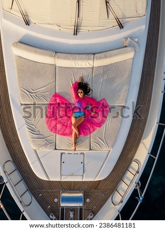 Luxury Yachting Experience: Aerial View of Glamorous Woman in Pink Dress