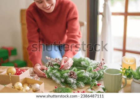 Woman making mistletoe wreath Christmas wreath decoration with hand made DIY winter greenery florist hands making Christmas wreath beautiful mistletoe