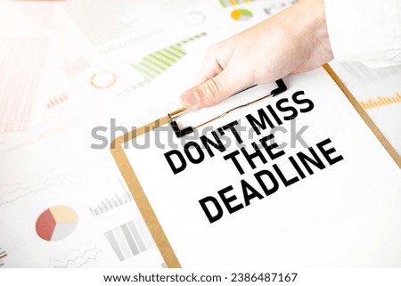 Text don't miss the deadline on white paper plate in businessman hands with financial diagram. Business concept