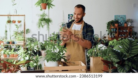 Man professional florists working at plants at flower shops. Hard work in greenhouse. African american male successful gardener wearing aprons smiling working. Startup, small business, flower shop.