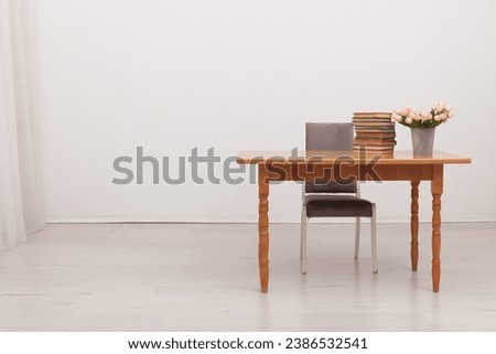 table with books and flowers and chair indoors interior cabinet