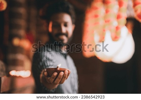 Closeup view of hand holding Diwali Diya with copy space for text, Indian Hindu festival concept photo, Happy Diwali 2023 background