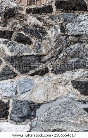 Rustic wall of cemented stones. Architectural element. Textured background with copyspace.