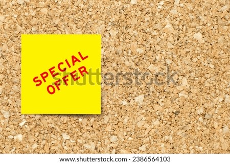 Yellow note paper with word special offer on cork board background with copy space