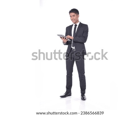 Full length portrait of young businessman using tablet standing isolated over white background