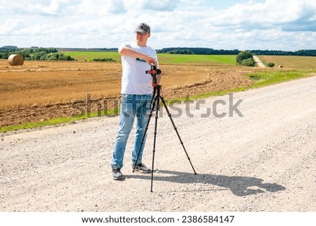 man on the road with a tripod taking photographs
