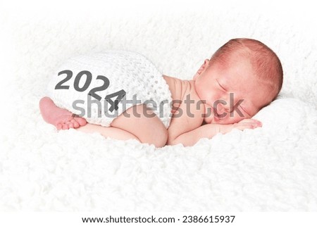 2024 Happy New Year baby. Newborn infant asleep on a white blanket.  Royalty-Free Stock Photo #2386615937