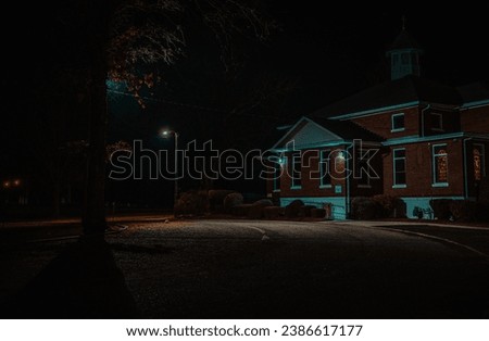 A nighttime shot of a residential street, illuminated by a lamp post. Royalty-Free Stock Photo #2386617177