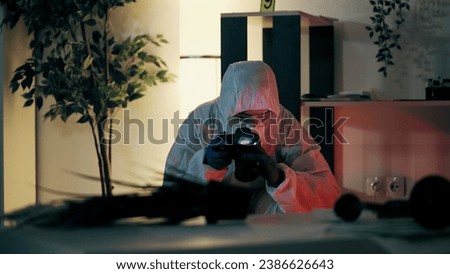 A forensic laboratory worker is taking pictures of the crime scene while collecting evidence