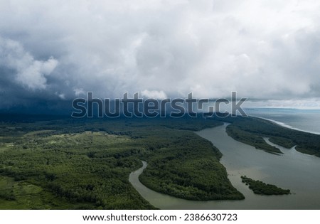 Storm front over meandering river and forest.