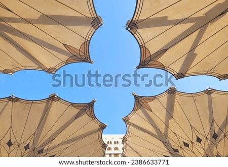 Large umbrella or canopy in the courtyard of the Nabawi Mosque, Saudi Arabia with a bright blue sky. Royalty-Free Stock Photo #2386633771