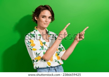 Photo of lovely pretty girl presenting promo banner new collection trendy spring clothes isolated on green color background