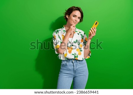 Photo of charming girl wear trendy print outfit hold modern gadget writing post social media messenger isolated on green color background