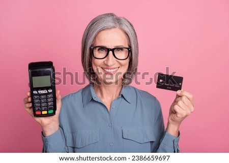 Photo of charming lovely retired lady wear trendy clothes hold bank terminal nfc cashless payment isolated on pink color background