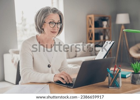 Photo of cheerful sweet senior lady freelancer dressed white cardigan preparing contract modern gadget indoors house room