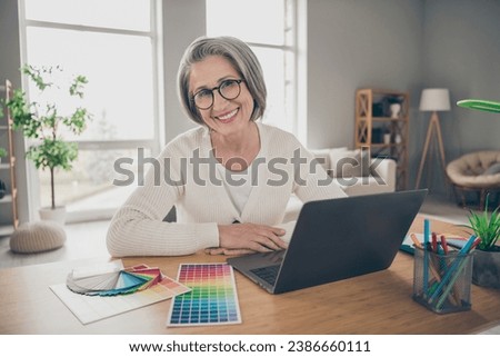 Photo of shiny good mood elderly lady designer wear white working modern device indoors apartment room