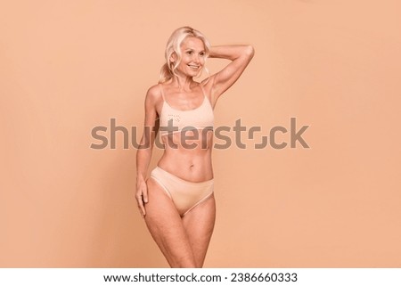 Photo of lovely charming lady dressed stylish panties looking empty space anti age wrinkles product isolated on beige color background