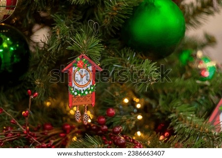 Christmas tree ornament in form of red house with clock. Holiday time. New Year.