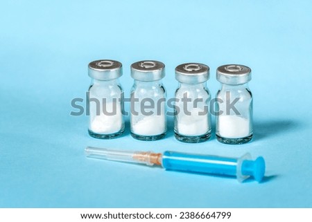 Syringe and needle with glass medical ampoule vials for injection. Medicine is dry white drug penicillin powder or liquid with of aqueous solution in ampulla Royalty-Free Stock Photo #2386664799