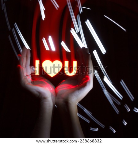 Light Painting Photography. Freezelight photo. Hands holding a red glowing massage with freezelight effect.