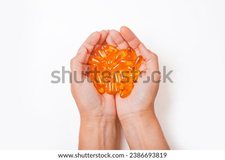 in the hands of a woman omega-3 capsules on a white background