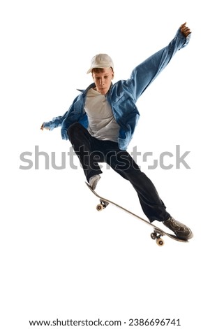 Teen boy, active guy in casual clothes in motion, training, practicing stunts on skateboard isolated over white background. Concept of professional sport, competition, training, action.