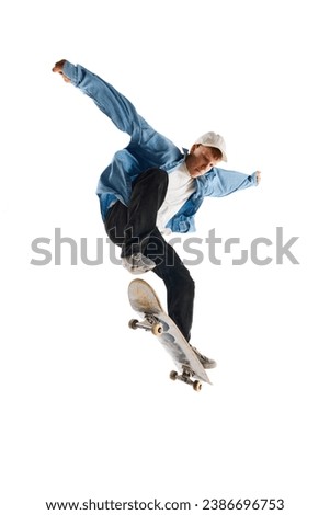 High jump. Active young man in casual clothes in motion, riding skateboard, training isolated over white background. Concept of professional sport, competition, training, action. Copy space for ad
