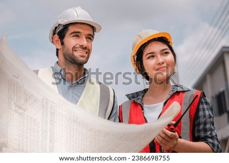 two professional engineer,worker,technician use clipboard discuss work, engineer supervising construction of building with construction worker.Architecture engineering in building site. architect. Royalty-Free Stock Photo #2386698755