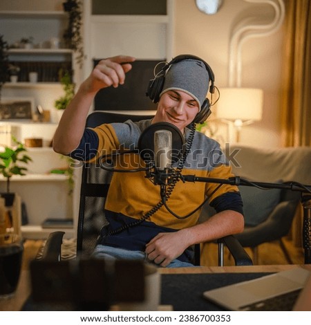 One man caucasian male blogger or vlogger gesticulating while streaming video podcast in broadcasting studio use microphone and headphones famous influencer shooting video for channel podcast Royalty-Free Stock Photo #2386700353