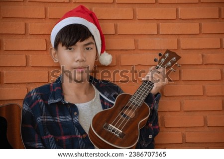 Asian cute boy with ukulele, children with popular instruments concept.