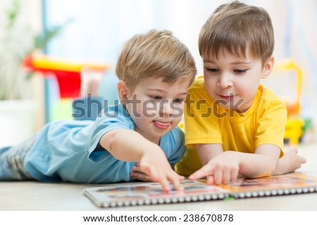 Cute little boys at home reading a book