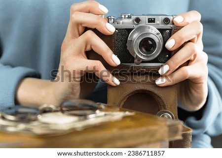 Women's hands operate an old camera.