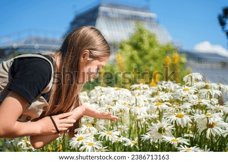 Young teen girl in colorful flower garden in Botanical Garden